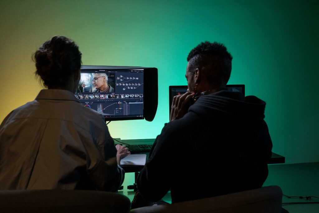 Dos profesionales revisan material audiovisual y corrección de color en monitores
