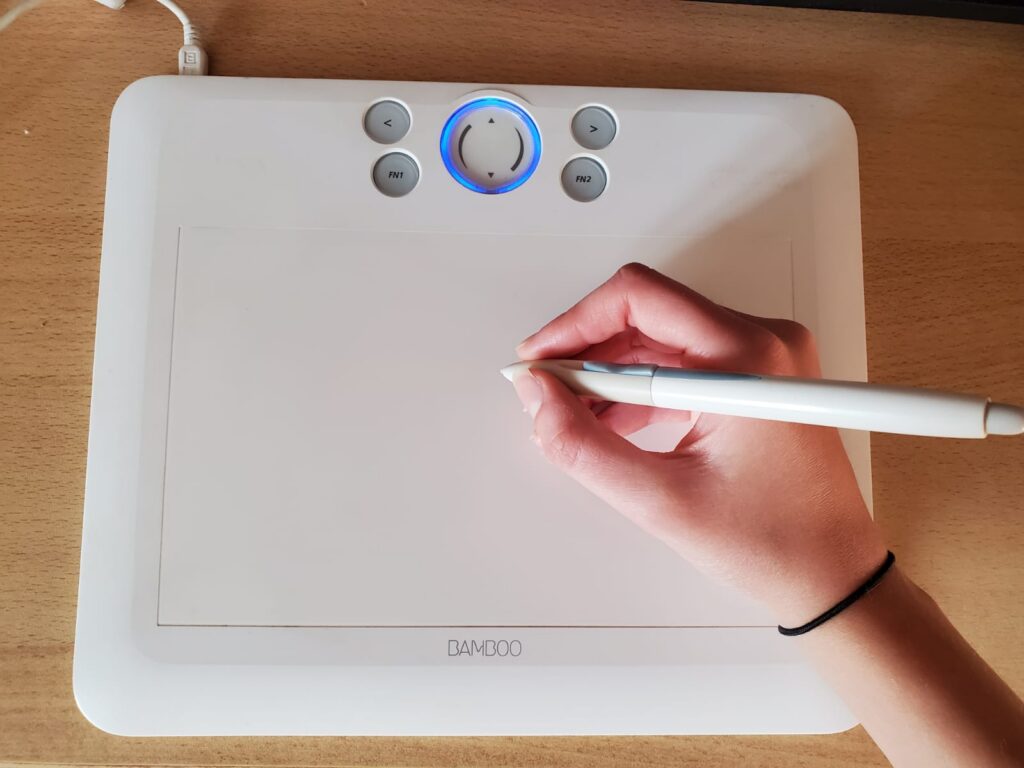Mano dibujando con un lápiz digital sobre una tableta gráfica