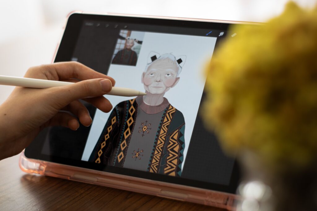 Manos dibujando un personaje en una tableta con lápiz digital