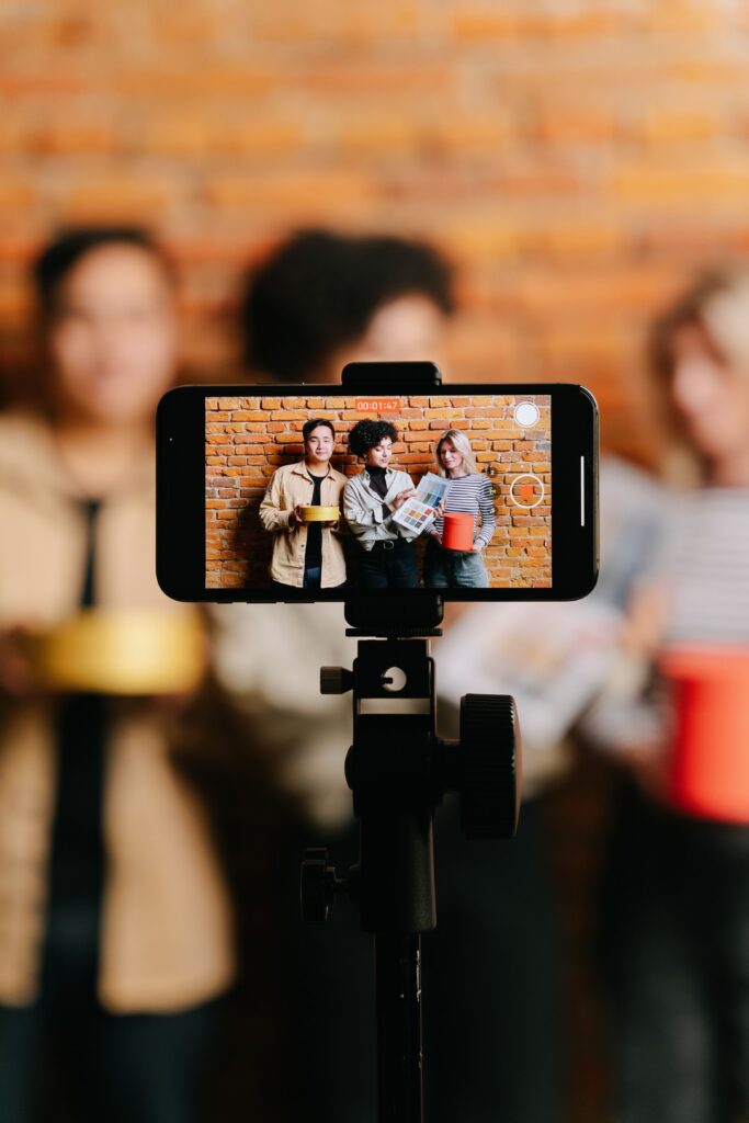 Grupo de jóvenes grabando contenido con un teléfono colocado en un trípode