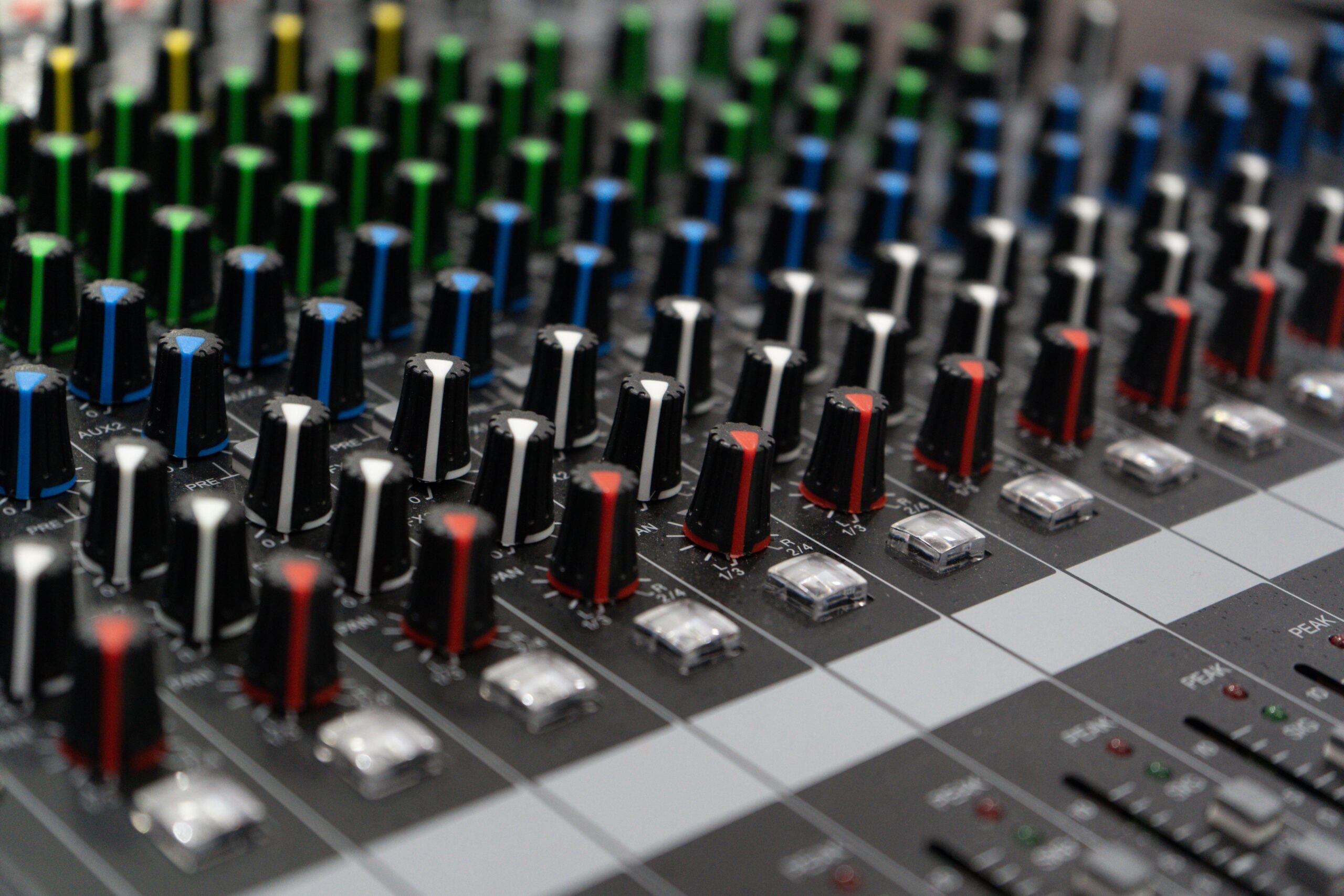 Filas de controles de colores en una consola profesional de audio