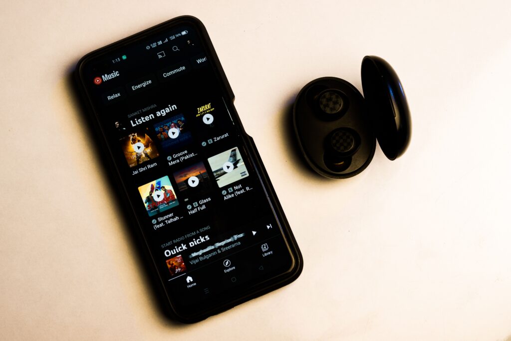 Teléfono con aplicación de música junto a audífonos inalámbricos