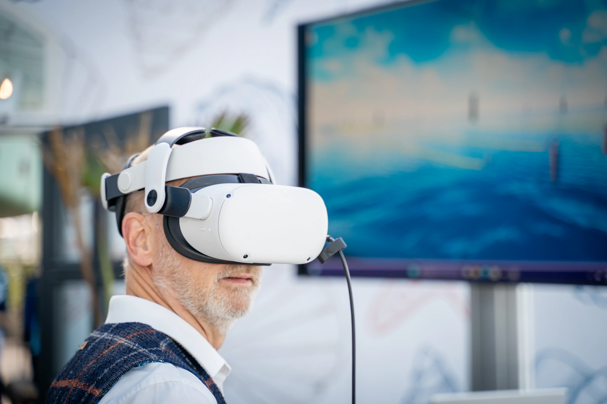 Persona con visor de realidad virtual frente a una computadora portátil