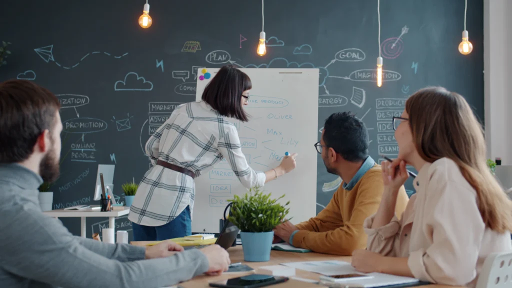 Equipo de trabajo organiza ideas y métricas frente a un pizarrón