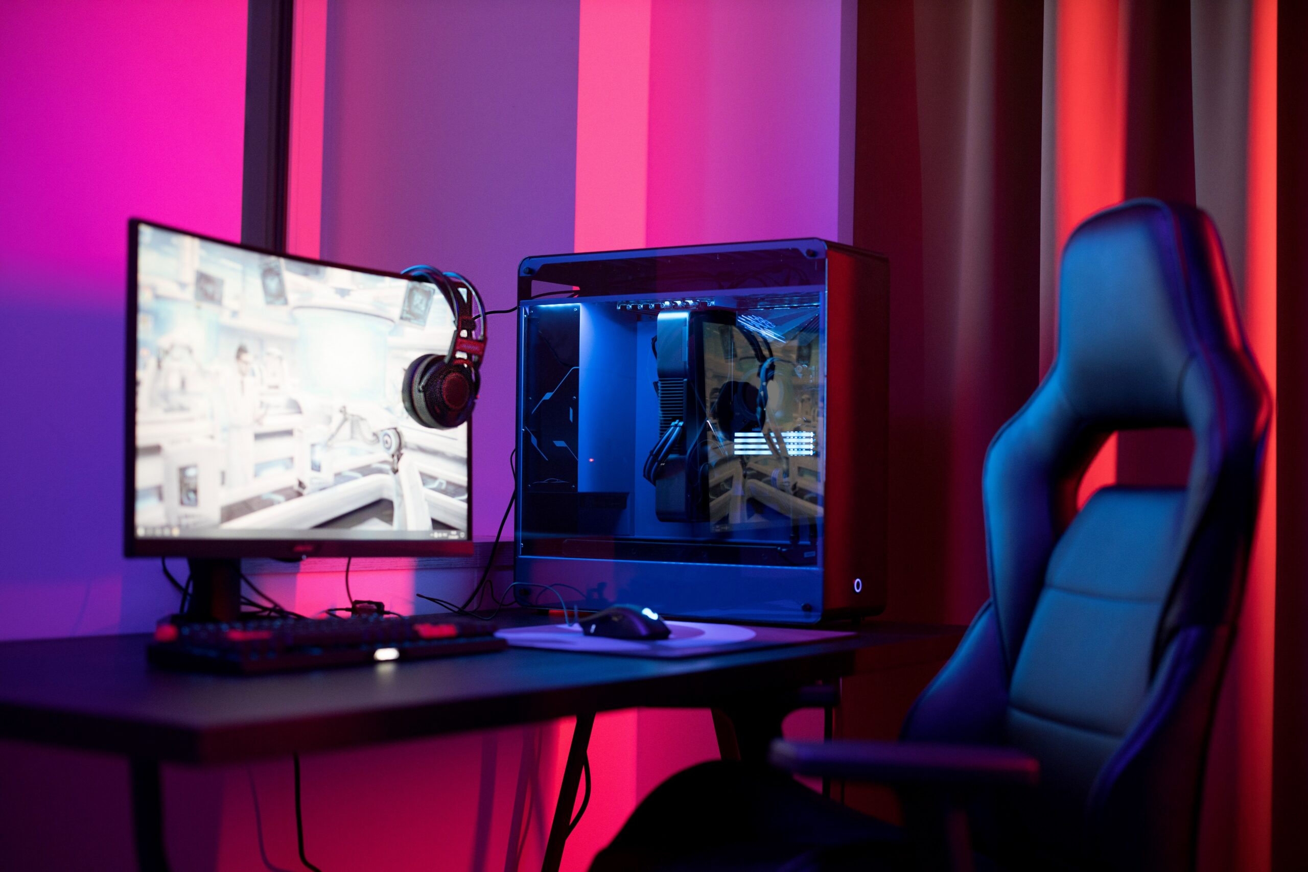Estación de videojuegos con monitor panorámico, computadora y luces de colores