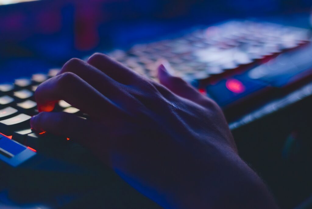 Mano utilizando un teclado iluminado durante una sesión de desarrollo