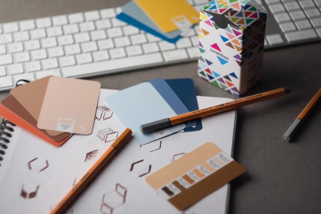 Muestras de color, lápices y teclado en una mesa de diseño