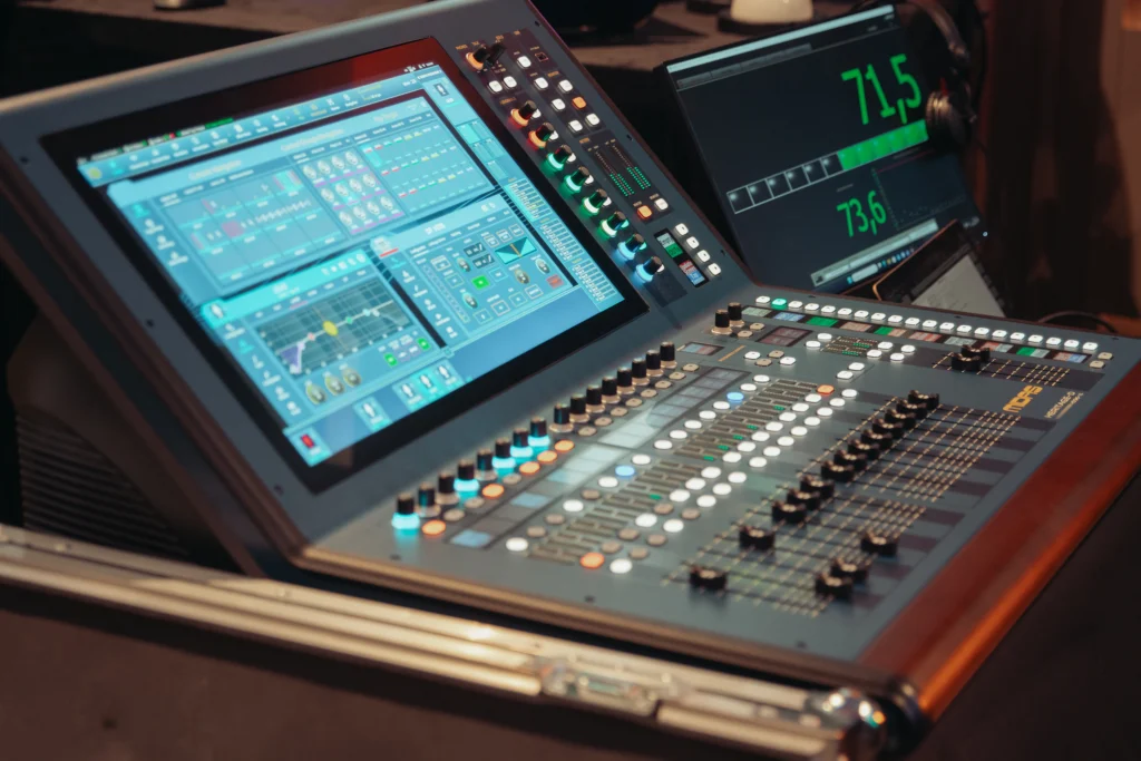 Consola profesional de audio con varios faders iluminados