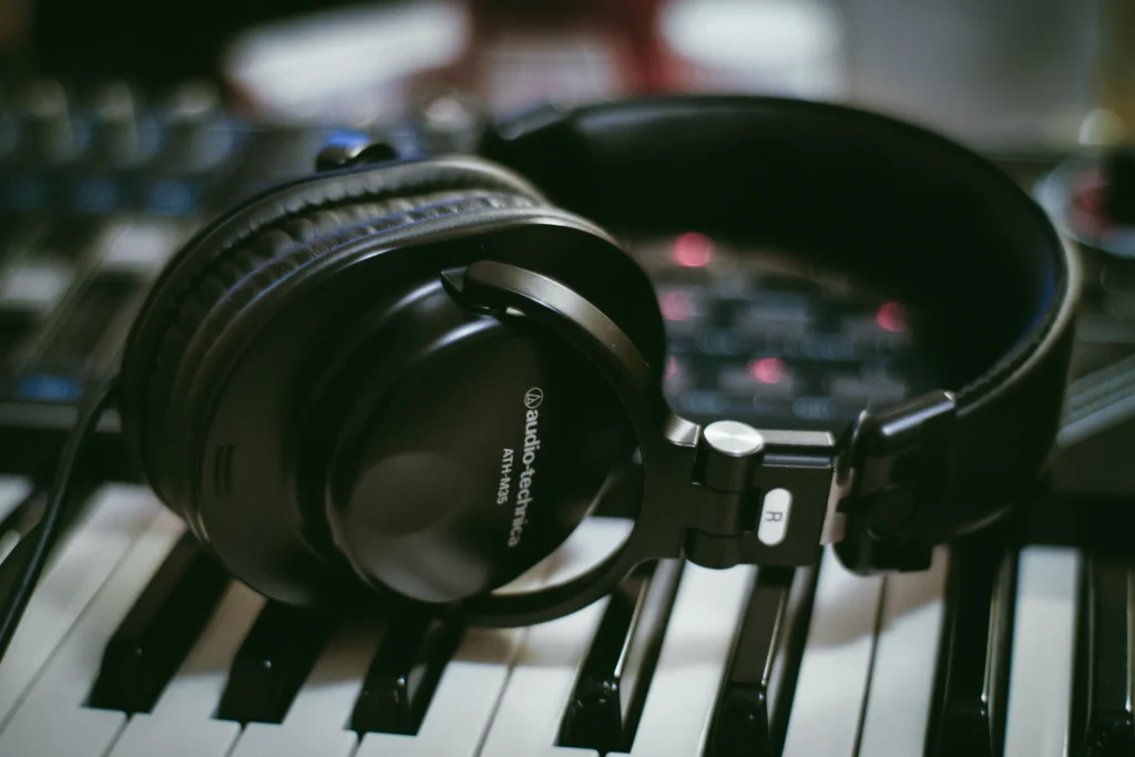 Audífonos negros colocados sobre un teclado musical en un estudio