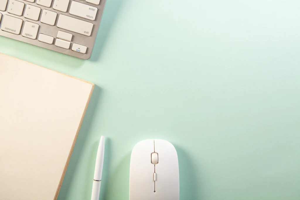Teclado, libreta, bolígrafo y ratón sobre un escritorio